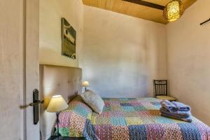 a bedroom with a bed with a colorful quilt at Castell del Montgrí in Torroella de Montgrí