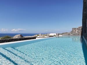 a large swimming pool in the middle of a beach at Canaves Oia Epitome - Small Luxury Hotels of the World in Oia