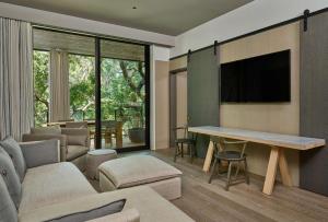 a living room with a couch and a table with a tv at Alila Napa Valley, a Hyatt Resort in St. Helena