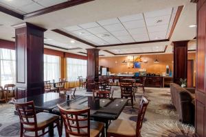 ein Restaurant mit Tischen und Stühlen und eine Bar in der Unterkunft Comfort Inn & Suites Denison - Lake Texoma in Denison