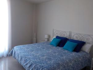 a bedroom with a blue bed with blue pillows at El Lagar De ElCiego in Elciego