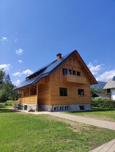 un gran edificio de madera con techo de gambrel en Cottage Suha, en Bohinj