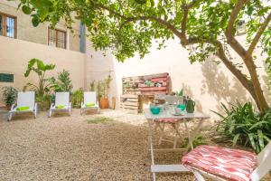 un patio avec des chaises, une table et un arbre dans l'établissement Ca Sa Tia (Sóller), à Sóller