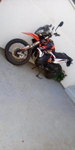 une moto est garée à côté d'un mur dans l'établissement Apartman Centar, à Mostar