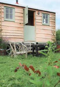 a house with a bench in front of it at The shepherds hut in Shrewsbury