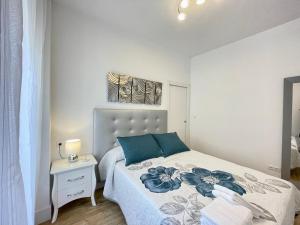 a bedroom with a bed with blue pillows on it at Apartamento Centro Alhóndiga Suite in Granada