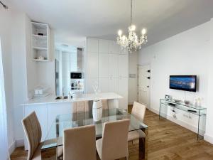 een eetkamer en een keuken met een glazen tafel en stoelen bij Apartamento Centro Alhóndiga Suite in Granada