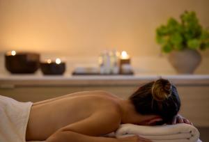 uma mulher deitada numa toalha numa casa de banho em Lucy Hotel em Kavala