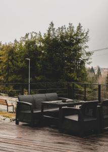 a picnic table and chairs on a wooden deck at Osada Poli - domek 3 in Koniaków