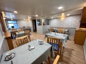 a dining room with tables and chairs in a restaurant at gwesTY Guest House in Aberystwyth
