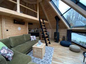 a living room in a tiny house with a ladder at Osada Poli - domek 3 in Koniaków