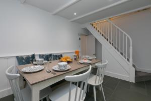 a dining room with a table and chairs and a staircase at Opechee in St Ives