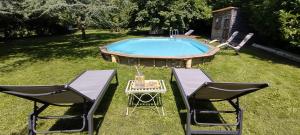 Balsac的住宿－Chateau de Balsac，游泳池畔的两把椅子和一张桌子