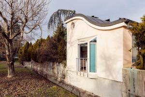 ein kleines weißes Haus mit einem blauen Fenster in der Unterkunft Sweet Sissi in Ljubljana