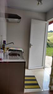 a kitchen with a white door and a counter top at Recanto das Videiras in Maria da Fé