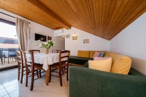a living room with a table and a couch at Apartments Tartuga in Rab