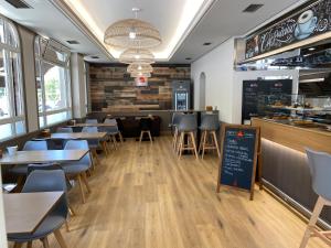 a restaurant with tables and chairs and a counter at Saudade Hostal Cafetería in A Coruña