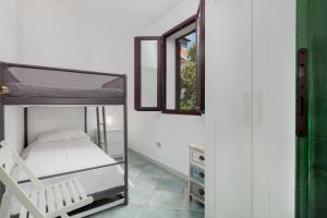 1 dormitorio con litera y ventana en APPARTAMENTO DEL CAPITANO, en Cala Gonone