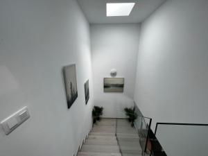 um corredor com paredes brancas e uma escada com duas fotografias em Arrecife exclusive beach house em Arrecife