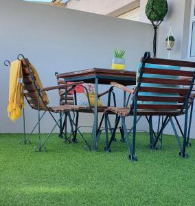 2 sillas y mesa de picnic con césped verde en Bellas Cottage, en Langebaan