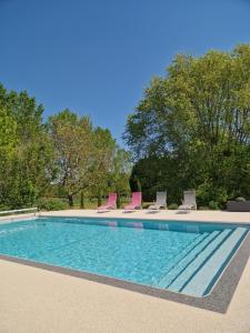 una piscina con sedie a sdraio di Chambre d'hôtes a La Membrolle-sur-Choisille