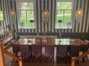 - une salle à manger avec une table, des chaises et des fenêtres dans l'établissement Hotel Randduin, à Oostkapelle