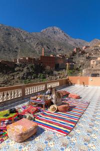 a group of people sitting on a rug on a roof at Amazigh Family Riad in Imlil