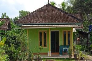 una casa verde con techo marrón en OYO HOMES 91255 Desa Wisata Embung Purworejo Syariah, 