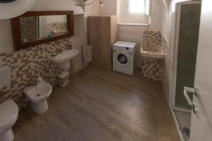 y baño con lavamanos y lavadora. en Sciacca32, en Sciacca