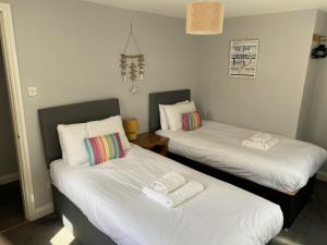 ウィットビーにあるThe Pier Innのベッド2台が隣同士に設置された部屋です。