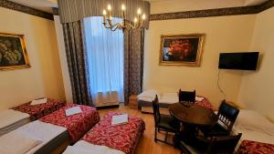 um quarto de hotel com duas camas e uma mesa e cadeiras em Vavelsky Apartments - Old Town em Cracóvia