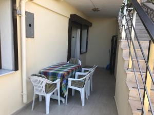 een tafel en stoelen op het balkon van een huis bij Teras butik apart in Karaburun