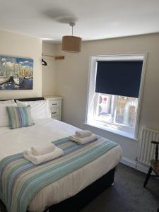 a bedroom with a bed with two towels on it at The Pier Inn in Whitby