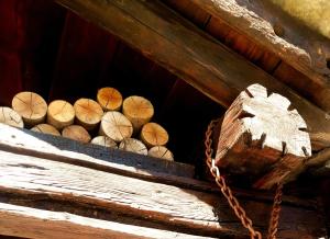 un mucchio di tronchi di legno in una scatola di legno con una catena di Maison Lazier a Châtillon