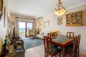 a dining room and living room with a table and chairs at Apartamento beira mar in Armação de Pêra