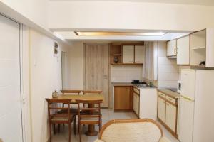 Apartment Ag.Foteinis في أثينا: مطبخ صغير مع طاولة وكراسي وثلاجة