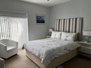 um quarto com uma cama, uma cadeira e uma janela em Wenden Guest House em Newquay