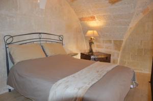 een slaapkamer met een bed en een lamp op een tafel bij Corte Soleto 22 in Martano
