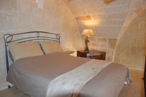 a bedroom with a bed and a lamp on a table at Corte Soleto 22 in Martano