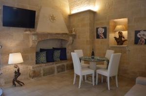 a living room with a table and a fireplace at Corte Soleto 22 in Martano