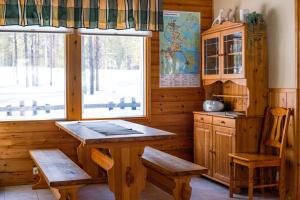 a kitchen with a table and two chairs and a window at Petäjäkylä in Kuusamo