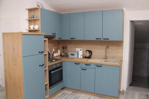 uma cozinha com armários azuis e um lavatório em Apartments Mara em Jelsa