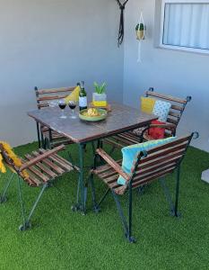 a table with two chairs and a plate of food on it at Bellas Cottage in Langebaan