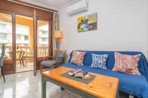 a living room with a blue couch and a table at Casa Miriam in Cala Ratjada