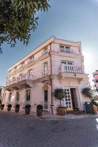 um edifício branco ao lado de uma rua em Giulia Albérgo Hotel em Durrës