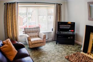 a living room with a chair and a television at 18 Sea View Close in Scarborough