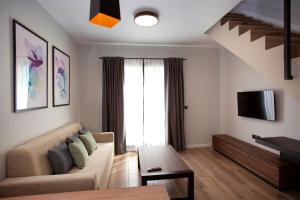 un soggiorno con divano e TV di Apartamentos La Espadaña a Rota