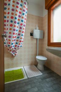 a bathroom with a toilet and a shower curtain at Hotel Adriaco in Grado