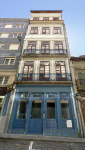 Habitatio - Aliados في بورتو: مبنى طويل مع أبواب ونوافذ زرقاء