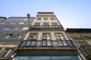 een hoog gebouw met ramen en een balkon bij Habitatio - Aliados in Porto